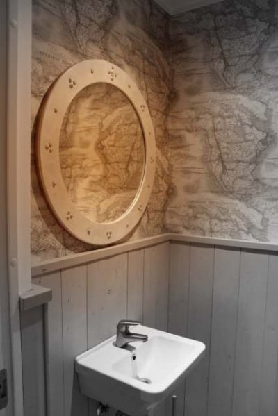 WC seinal on maakaardi mustriga tapeeti ja seinal Iris Jurma disainitud peegel
