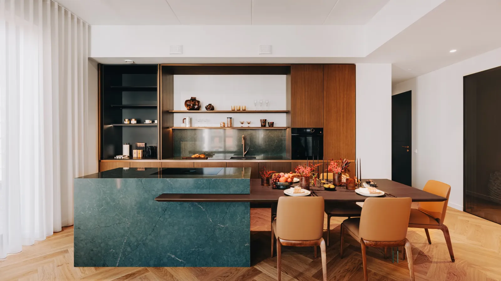 Ekstrasuurt köögisaart rõhutab marmoriimitatsiooniga rohekas sinine kvarts Silestone Jardin Emerald ning integreeritud õhupuhasti-pliidilahendus hoiab pinna üldmulje puhta ja minimalistliku. Foto: Volta Galerii Loftid, näidiskorter, köök, sisekujundus Palazzo Interiors.